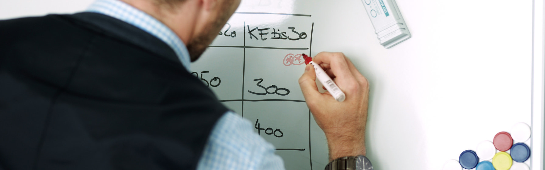 Mann schreibt auf Whiteboard